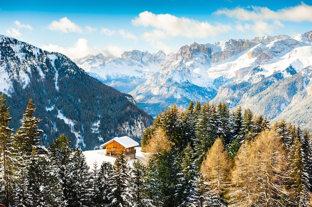 Casa de madera en las montañas de invierno. Alpes Dolomitas, Val di Fassa, Italia