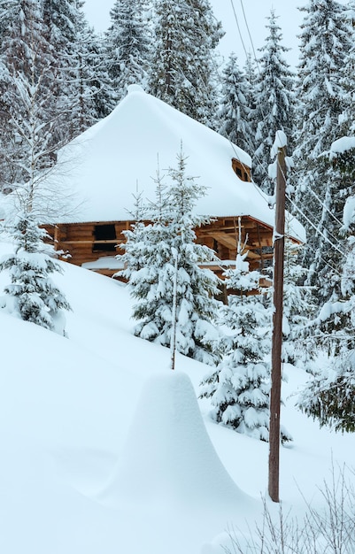 Casa de madera en pendiente de invierno