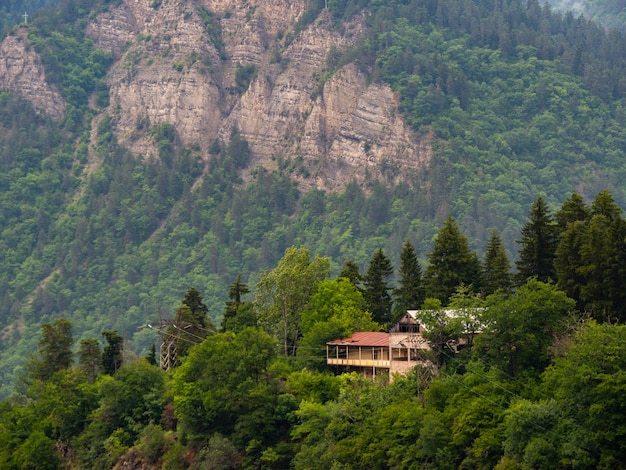 Casa de madera perdida en el bosque de las montañas. Atmósfera de tranquila soledad. El cielo introvertido.