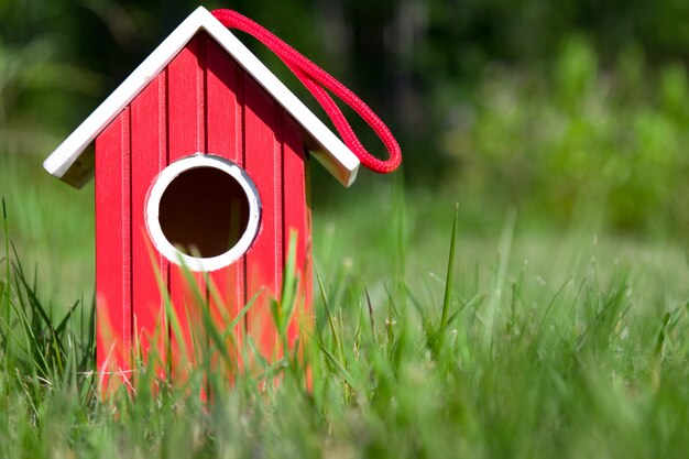 Casa de madera roja en jardín. Casa del pájaro