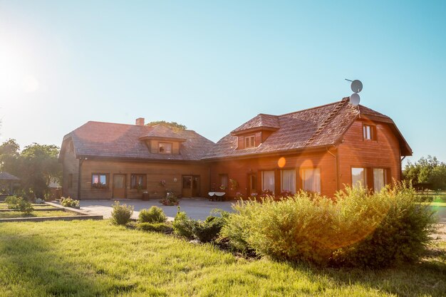 Casa de madera rústica con techo inclinado y antena parabólica en el campo