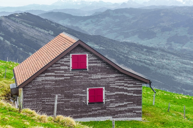 casa de madera sobre la hierba verde con fondo de vista a la montaña