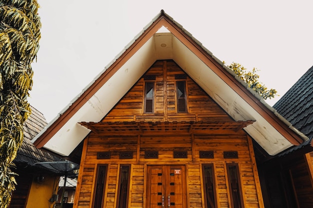 Una casa de madera con techo blanco y techo negro.