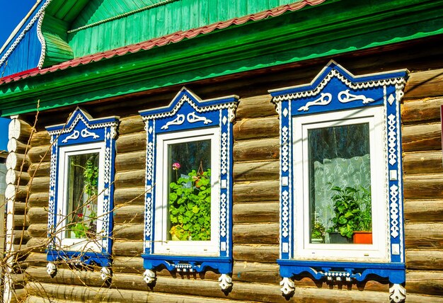 Una casa de madera con ventanas con molduras azules y molduras blancas.