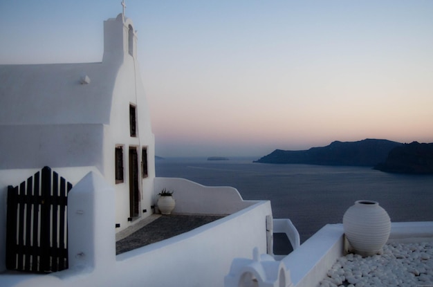 Casa y mar contra el cielo durante la puesta de sol