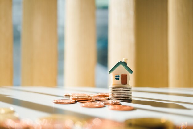 Casa miniatura en monedas de pila usando como propiedad y concepto financiero
