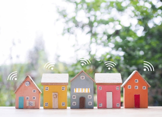 Casa en miniatura con señal Wi-Fi El concepto de conexión a la red Internet de las cosas tecnología de control y sistema de automatización de hogares inteligentes