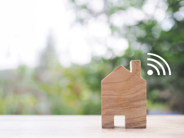 Foto casa en miniatura con señal wi-fi el concepto de conexión a la red internet de las cosas tecnología de control y sistema de automatización de hogares inteligentes