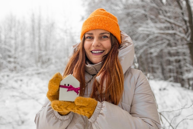 Casa modelo branca em mãos de mulher sistema de aquecimento inverno ou temporada fria conceito espaço de cópia para texto