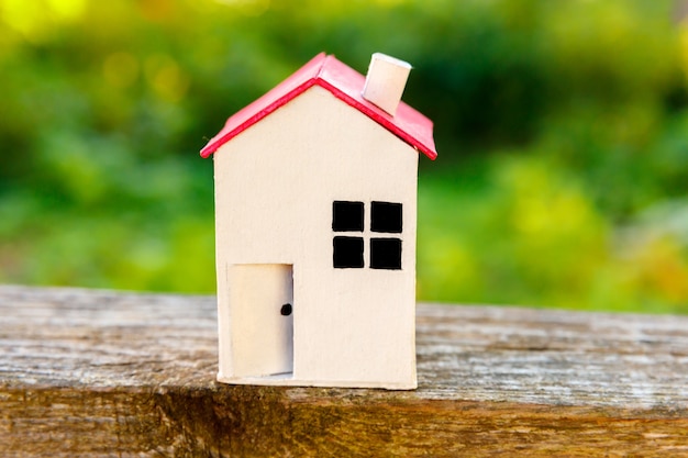 Casa modelo de juguete blanco en miniatura en fondo de madera cerca de fondo verde eco pueblo abstracto enviro ...