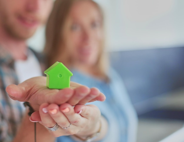 Foto casa modelo en la mano de una pareja de pie en una nueva casa modelo