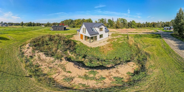 Casa moderna de nueva construcción con techo de metal y grandes ventanas en un entorno rural