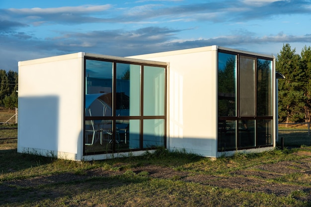 Casa modular com janelas panorâmicas na orla de uma floresta de pinheiros