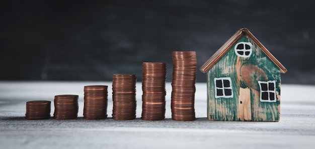 Casa y monedas sobre la mesa.