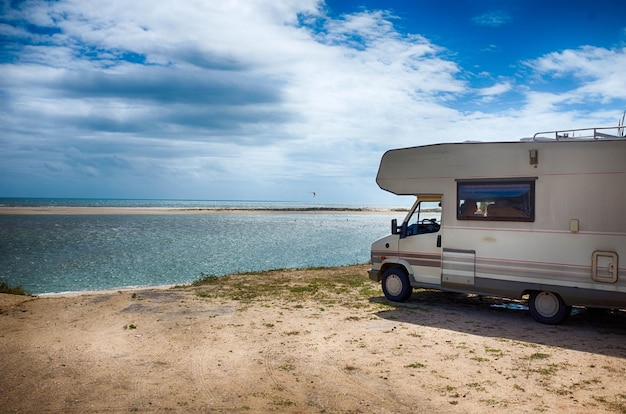 Casa con motor estacionada en la playa contra el cielo