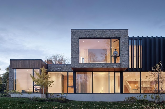 una casa con muchas ventanas y una persona de pie en las escaleras