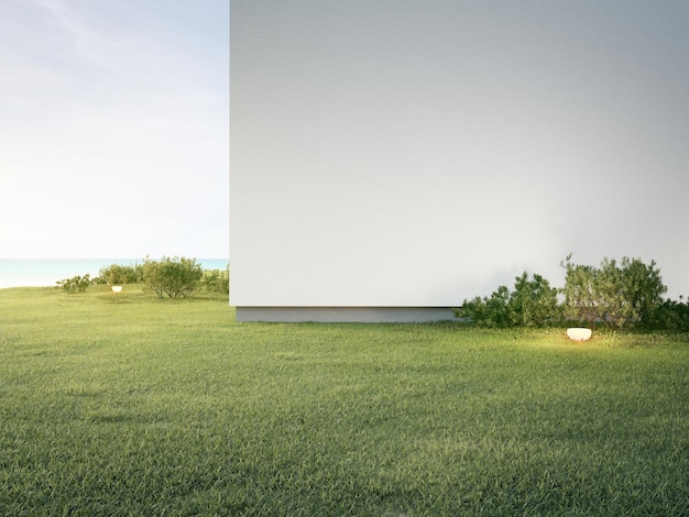 Casa con muro de hormigón blanco cerca del suelo de hierba vacío. Representación 3d de césped verde en casa moderna.