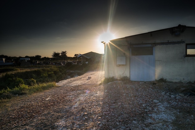 Foto casa no meio das árvores contra o céu durante o pôr-do-sol