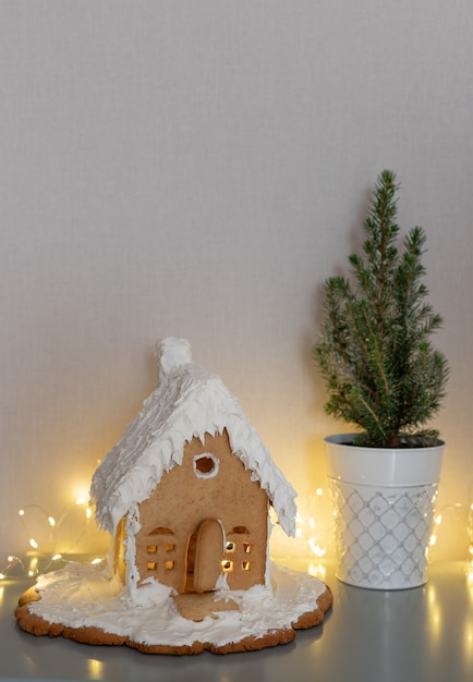 Casa de pan de jengibre árbol de Navidad en macetas y luces parpadeantes en la sala de estar escena navideña