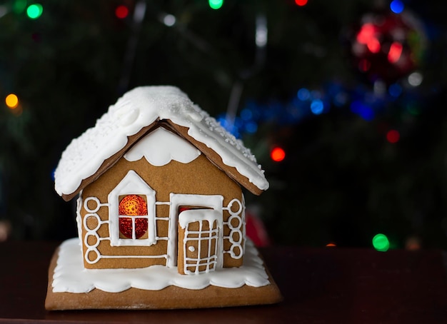 casa de pan de jengibre, comida navideña, fondo de año nuevo, luces navideñas en el árbol