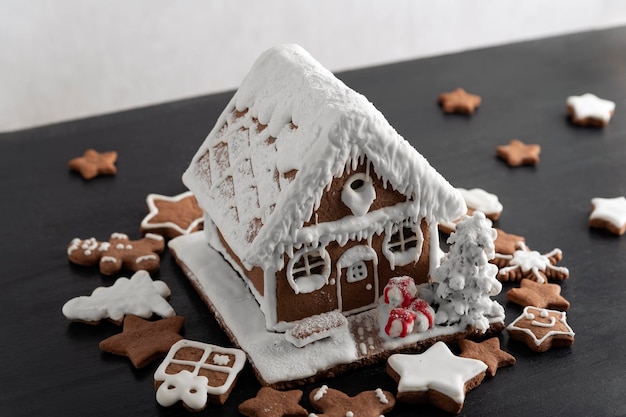 Casa de pan de jengibre rodeada de galletas de jengibre Productos horneados de Navidad