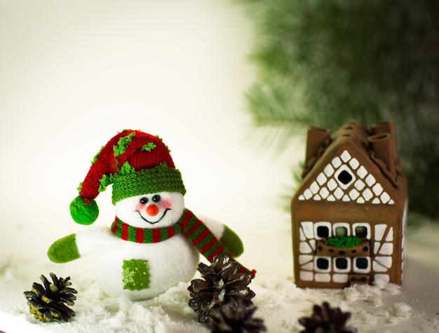 Casa de pan de jengibre sobre el encantador muñeco de nieve artesanal