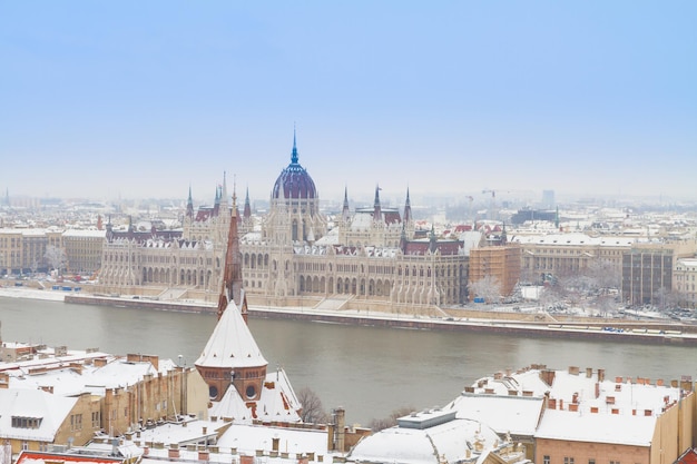 Casa del parlamento sobre tejados nevados de la colina de Buda en el día de invierno, Budapest, Hungría