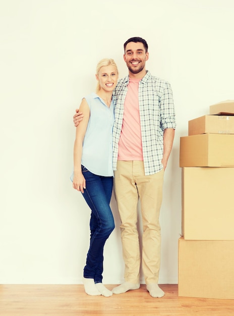 casa, pessoas, reparação e conceito imobiliário - casal feliz com muitas caixas de papelão se mudando para um novo lugar