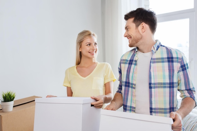 casa, pessoas, reparação e conceito imobiliário - casal sorridente com grandes caixas de papelão movendo-se para um novo lugar