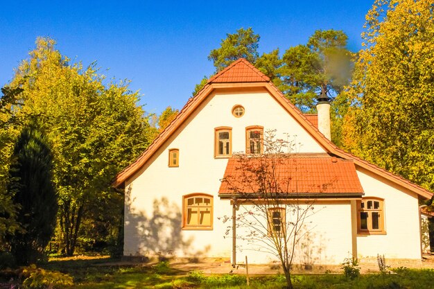 Casa de pueblo blanco en el bosque de otoño