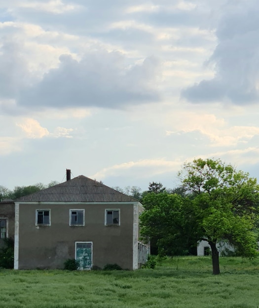 Una casa con una puerta verde está en la hierba.