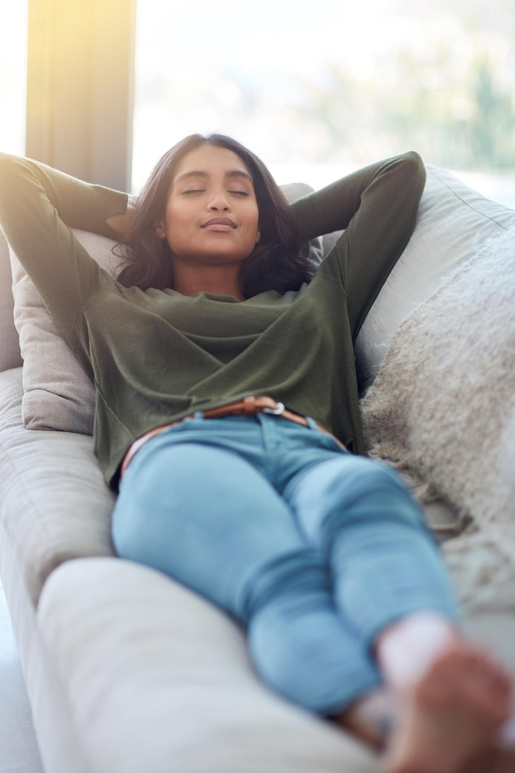 Foto casa relaxar e mulher no sofá dormir e respirar com sesta da tarde olhos fechados e calmo na sala de estar apartamento pessoa feliz e menina no sofá zen e mão atrás da cabeça com pausa e descanso