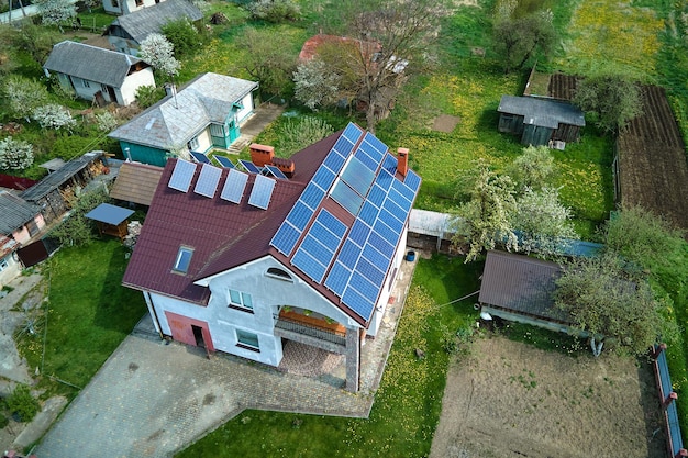 Casa residencial com telhado coberto com painéis solares fotovoltaicos para produção de energia elétrica ecológica limpa em área rural suburbana conceito de casa autônoma