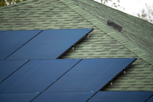 Casa residencial comum nos EUA com telhado coberto com painéis solares para a produção de eletricidade ecológica limpa em área rural suburbana Conceito de investir em casa autônoma para economia de energia