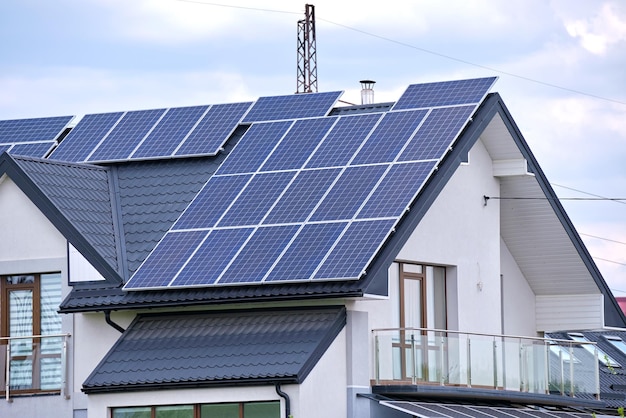 Casa residencial con techo cubierto con paneles solares fotovoltaicos para la producción de energía eléctrica ecológica limpia en una zona rural suburbana Concepto de casa autónoma