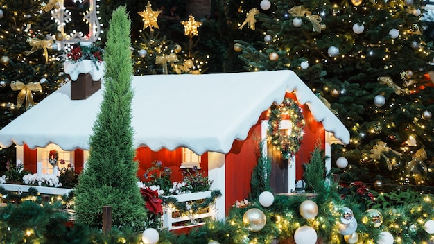 Casa roja brillante adornada con nieve blanca y decoraciones festivas con copos de nieve