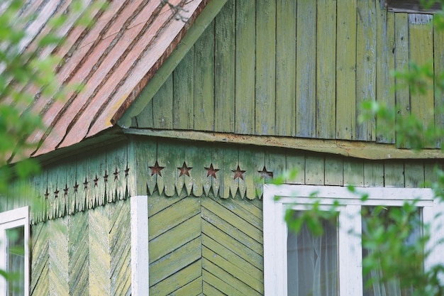 casa rústica de madera con techo rojo triangular y símbolos de estrellas rojas en el diseño