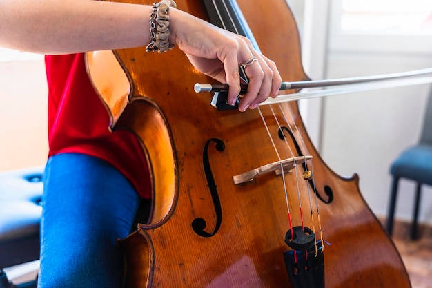 Foto casa serenade estúdio celista talentosa e seu violoncelo vintage