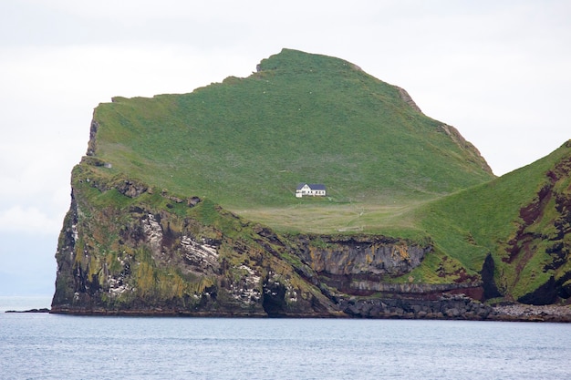 Foto casa solitária na ilha do arquipélago vestmannaeyjar. islândia