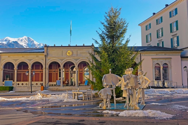 Casa de spa con monumento a la gente y montañas. Bad Ragaz es una ciudad en St. Gallen en Suiza, sobre los Alpes de Graubunden. El spa y la recreación están en el valle de Tamina.