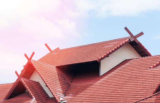 Casa de techo rojo con techo de tejas en el cielo azul