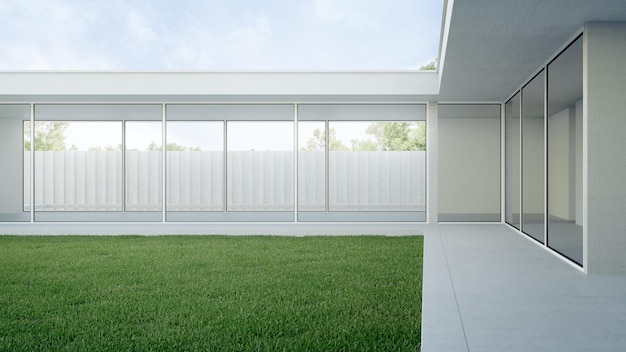 Casa con terraza de hormigón cerca del patio vacío con suelo de hierba.