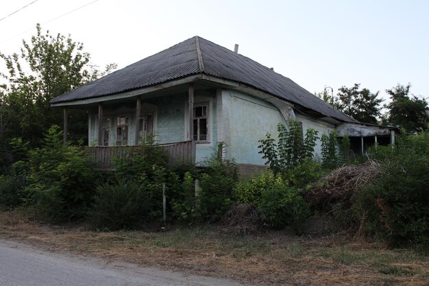 Una casa con una valla y arbustos.