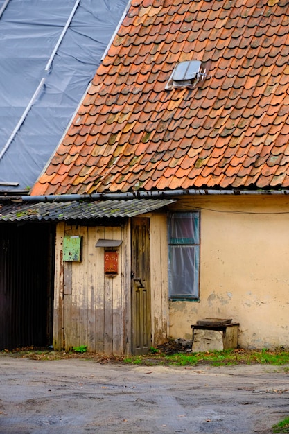 Casa velha com caixa de correio de varanda de madeira e azulejos vermelhos desbotados