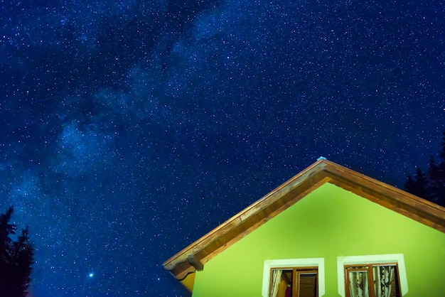 Casa verde sob o céu noturno azul escuro