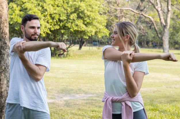 Casais estão se exercitando no parque.