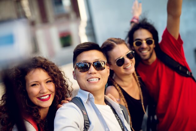 Foto casais multirraciais explorando uma cidade, turistas felizes descobrindo novos locais. fazendo selfie.