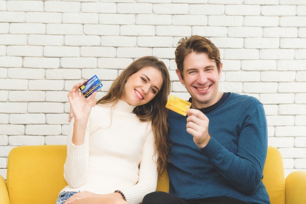 Casais segurando o cartão de crédito mostram.