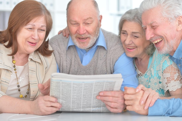 Casais sênior lendo jornal