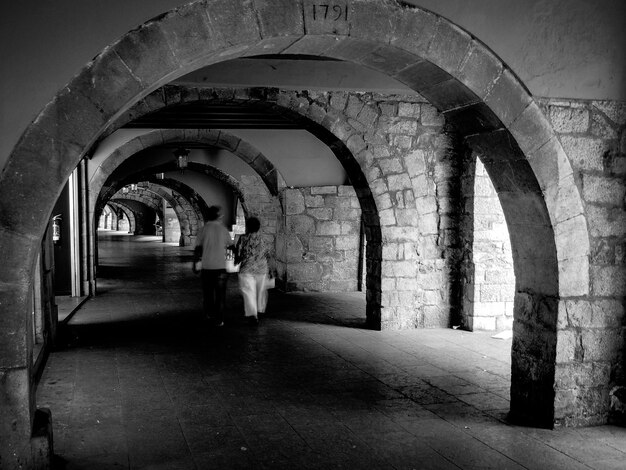 Foto casal a caminhar no arco do edifício